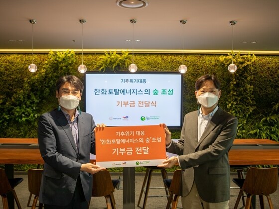 지난 18일 한화토탈에너지스 관계자(오른쪽)가 김종우 사단법인 푸른아시아 실장(왼쪽)에게 기부금을 전달하고 있다.(한화토탈에너지스 제공) © 뉴스1
