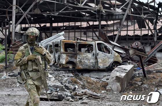 18일 (현지시간) 러시아가 점령한 마리우폴의 파괴된 일리치 제철소 주변을 병사가 순찰을 하고 있다. © AFP=뉴스1 © News1 우동명 기자