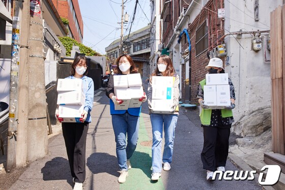 숙명여대 봉사단이 서울역 인근 쪽방촌 주민들에게 나눠줄 생필품을 옮기고 있다. (숙명여대 제공) © 뉴스1