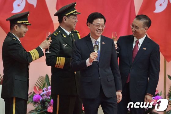2021년 7월 1일 당시 존 리(왼쪽 두 번째) 홍콩 행정장관 권한대행이 홍콩반환일 행사에서 기뻐하는 모습. 경찰 출신의 존 리 전 보안국장은 8일 새 행정장관에 선출됐다. © AFP=뉴스1 © News1 최서윤 기자