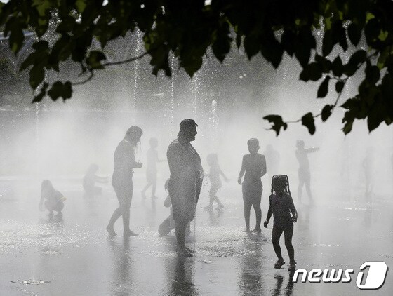 14일(현지시간) 스페인 마드리드 리오 파크에서 시민들이 폭염을 피해 분수 근처에서 물을 맞으며 더위를 식히고 있다. © 로이터=뉴스1 © News1 유민주 기자