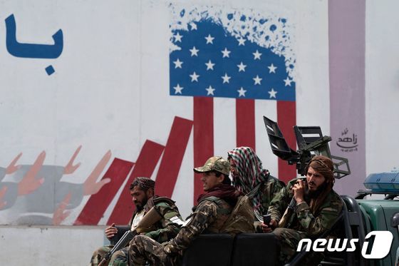 12일(현지시간) 아프가니스탄 수도 카불 소재 미국 대사관 벽 앞에 탈레반 정부군이 군용차량을 타고 지나가고 있다. 2022.04.12 © AFP=뉴스1 © News1 정윤미 기자