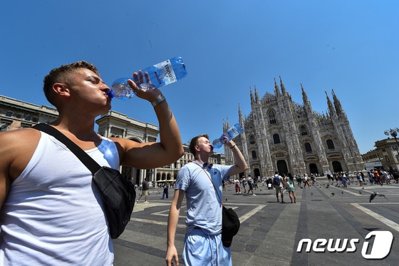 이탈리아 밀라노 두오모 성당 앞에서 찌는 듯한 폭염 속 물을 마시는 행인의 모습. 2022. 7. 21. © 로이터=뉴스1 © News1 최서윤 기자