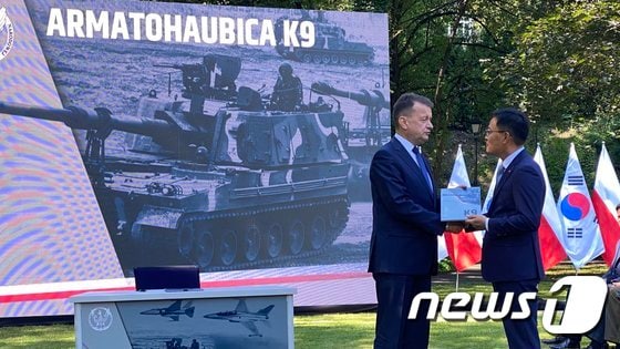 손재일 한화디펜스 대표이사(오른쪽)와 마리우시 브와슈차크 장관이 27일(현지시간) 폴란드 바르샤바에서 K9 자주포, K10 탄약운반장갑차, K11 사격지휘장갑차 등을 수출하기 위한 기본계약을 체결하고 있다. (한화디펜스 제공) 2022.7.28/뉴스1