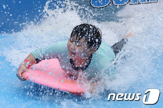 폭염이 찾아온 3일 오후 대구 달서구 테마파크 이월드에서 한 어린이가 서핑머신에 몸을 맡긴 채 물놀이를 즐기고 있다.2022.7.3/뉴스1 © News1 공정식 기자
