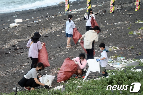 제주 서귀포시 안덕면 사계리 해변에 버려진 플라스틱 쓰레기를 시민들이 치우고 있다. 2022.7.30/뉴스1 © News1 오미란 기자