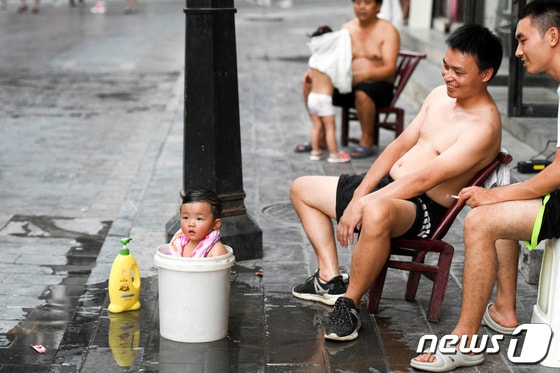중국 남동부 후난성에서 한 어린이가 양동이에 몸을 담그고 있다. 2022. 8. 15. © 로이터=뉴스1 © News1 최서윤 기자