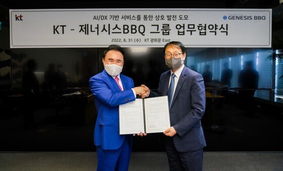 31일 윤홍근 제너시스BBQ 회장(왼쪽)과 구현모 KT 대표가 AI·DX 분야 협력을 위한 업무협약 체결 후 기념촬영을 하고 있다.(BBQ 제공) 