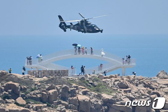 중국 관광객들이 4일 푸젠성 핑탄섬을 지나 날아가는 중국군 헬리콥터를 지켜보고 있다. 2022. 8. 4. © AFP=뉴스1 © News1 이종덕 기자