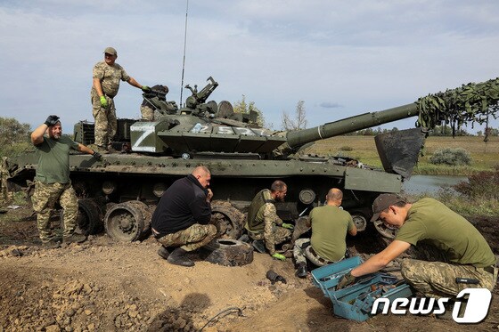 우크라이나 군인들이 20일(현지시간) 우크라이나 하르키우 지역 러시아 접경 지역에서 러시아군 탱크를 노획해 수리하고 있다. © 로이터=뉴스1 © News1 김민수 기자