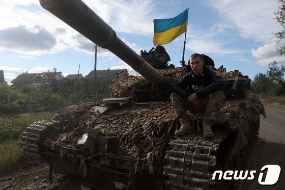 22일 (현지시간) 최근 러시아 군의 공격을 격퇴한 우크라이나 도네츠크 돌리나 도로에서 병사가 탱크 위에 앉아 있다. © AFP=뉴스1 © News1 우동명 기자