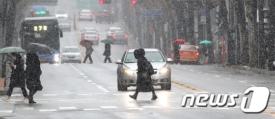 눈이 내리는 15일 서울 동대문구 이문동에서 시민들이 발걸음을 재촉하고 있다. 2023.1.15/뉴스1 © News1 박지혜 기자