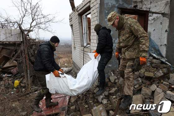 18일(현지시간) 우크라이나 동부 도네츠크주 돌리나에서 우크라이나 자원봉사자들이 마을에 묻힌 러시아군 시신을 발굴해 운반하고 있다. 2023.1.18. © AFP=뉴스1 © News1 김성식 기자