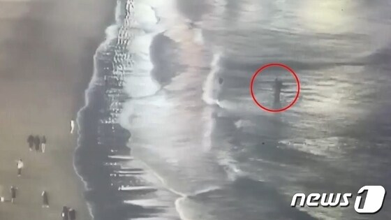 사건이 발생한 지난 27일 오후 7시48분 부산 수영구 광안리해수욕장. 빨간색 동그라미가 경찰이 모녀를 구조하는 모습.(부산경찰청 제공)