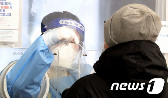 서울 중구 서울역 코로나19 선별진료소에서 마스크를 착용한 의료진이 PCR검사를 위한 검체를 채취하고 있다./뉴스1 © News1 장수영 기자