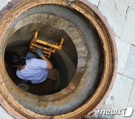  2022년 여름 경기 남양주시 소속 수도검침원이 계량기 확인을 위해 맨홀 안으로 들어가고 있다. /뉴스1 양희문 기자