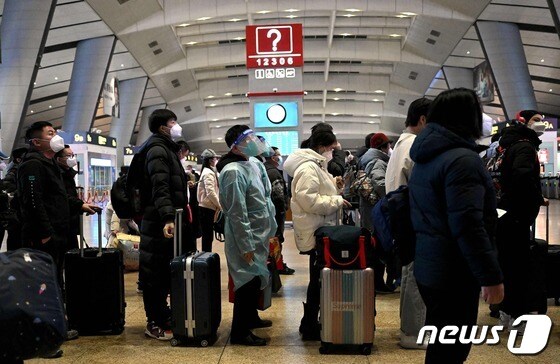 5일(현지시간) 코로나19 확산 속 중국 베이징 기차 역에서 방호복을 입은 승객이 줄을 서 있다. © AFP=뉴스1 © News1 우동명 기자