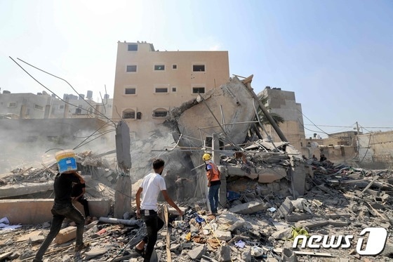 14일 (현지시간) 팔레스타인 무장 정파 하마스의 공격에 대응해 지상전을 준비 중인 이스라엘 군의 공습을 받은 가자 지구 칸 유니스에서 허물어진 건물이 보인다. 2023.10.15 © AFP=뉴스1 © News1 우동명 기자