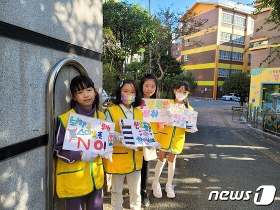 교통안전 포스터를 들고 있는 광일초 학생들의 모습(광일초 녹색어머니회 제공) 
