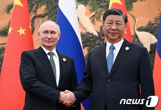 18일(현지시간) 중국 베이징에서 블라디미르 푸틴 러시아 대통령(왼쪽)과 시진핑 중국 국가주석이 손을 잡고 포즈를 취하고 있다. 2023.10.18 © AFP=뉴스1 © News1 정지윤 기자