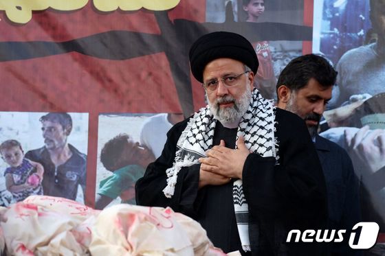 에브라힘 라이시 이란 대통령이 18일(현지시각) 테헤란의 혁명 광장에서 열린 반이스라엘 집회에 참석해 희생 당한 팔레스타인 아이들을 상징하는 더미를 놓고 두 손을 가슴에 얹고 있다. 2023.10.19 © AFP=뉴스1 © News1 우동명 기자
