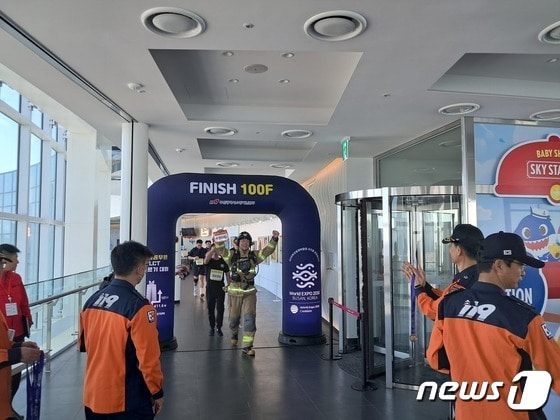 부산 해운대LCT 계단오르기 대회 참가자가 100층 결승선에 도착해 환호하고 있다. (부산소방재난본부 제공)