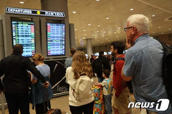7일(현지시간) 이스라엘 텔아비브의 벤 구리온 국제 공항에서 승객들이 항공편 게시판을 바라보고 있다. 이날 이스라엘에서는 하마스의 대규모 공격을 받아 비행편이 잇따라 취소되거나 축소됐다. 2023.10.07/ © AFP=뉴스1 © News1 