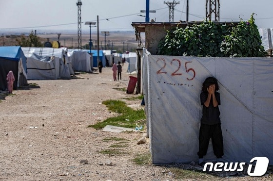 8일(현지시간) 시리아 북동부 하사카주(州) 알마일카 외곽 지역에 사는 한 어린이가 벽 뒤로 숨어 있다. 2023.10.09/ © AFP=뉴스1 © News1 권진영 기자