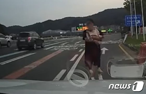  지난달 4일 오후 6시께 대전톨게이트 인근 고속도로에서 맨발로 뛰어다니는 아이를 구조한 운전자. (유튜브 '한문철 TV')