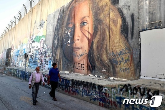 서안 지구 베들레헴 분리장벽에 팔레스타인 활동가 아헤드 타미미의 초상화가 그려져 있다. 23.11.06 © AFP=뉴스1 © News1 김예슬 기자