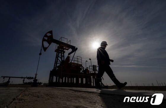  카자흐스탄 망기스타우 지역의 제티베이 유전에서 석유 및 가스 업계 근로자가 시추 장비를 작동하는 동안 걸어가고 있다. 2023.11.13 © 로이터=뉴스1