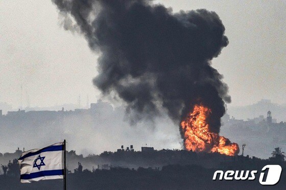 8일(현지시간) 팔레스타인 무장 정파 하마스와 전쟁 중인 이스라엘 군의 포격을 받은 가자 지구 국경서 화염이 솟아 오르고 있다. 2023.11.9 © AFP=뉴스1 © News1 우동명 기자