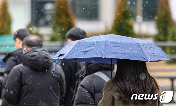 전국 곳곳에 눈이 예보된 19일 서울 종로구 광화문네거리에 우산을 쓴 시민이 길을 지나가고 있다. 2023.12.19/뉴스1 © News1 김도우 기자
