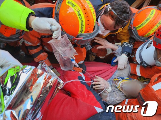 지난11일(현지시간) 튀르키예 지진 피해 지역에서 대한민국 긴급구호대 대원들이 65세 여성 생존자를 구조하고 있다. (대한민국 긴급구호대(KDRT)제공) 2023.2.12/뉴스1