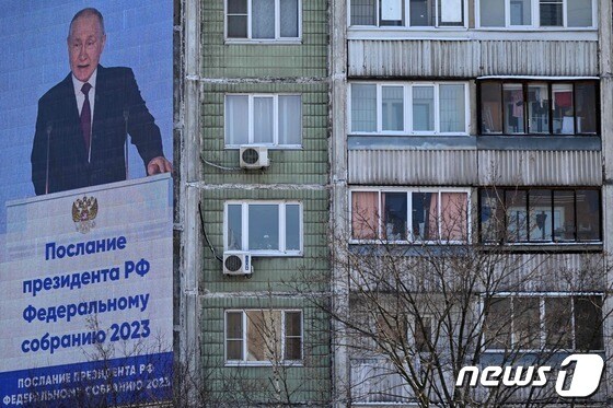 블라디미르 푸틴 러시아 대통령의 21일 국정 연설을 앞두고 모스크바의 한 건물 옆에 그의 사진을 담은 화면이 걸려 있다. © AFP=뉴스1 © News1 강민경 기자