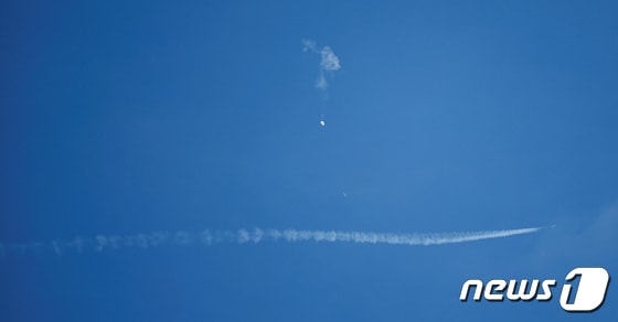4일(현지시간) 미국 사우스캐롤나이나주 서프사이드 해안에서 중국 정찰 풍선으로 추정되는 비행체가 떨어지는 모습. 아래 흰선은 정찰 풍선을 감시하기 위한 전투기의 궤적이다. © 로이터=뉴스1 © News1 박형기 기자
