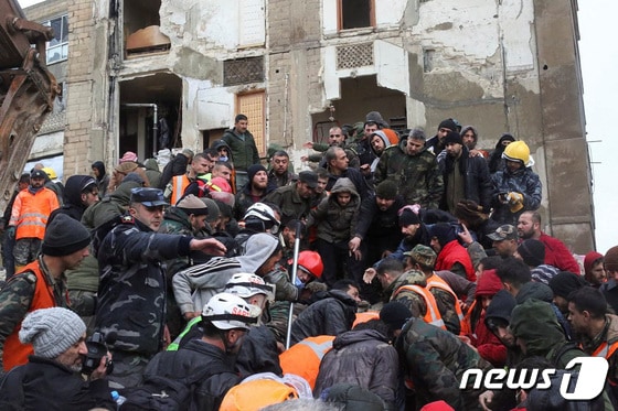 6일(현지시간) 시리아 하마에서 지진 잔해에 깔린 생존자를 구출하는 구조대원들 주위로 사람들이 구름떼처럼 모여들었다. © 로이터=뉴스1 © News1 권진영 기자