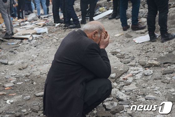 6일(현지시간) 튀르키예(터키) 디야르바키르에서 발생한 지진 후 잔해 속에서 생존자를 찾고 있다. 한 남성이 구조현장에서 얼굴을 감싸고 오열하는 모습. 튀르키예와 시리아 측 발표에 따르면 이날 지진으로 인한 사망자는 1400명을 넘었다. 23.02.06 © AFP=뉴스1 © News1 김예슬 기자