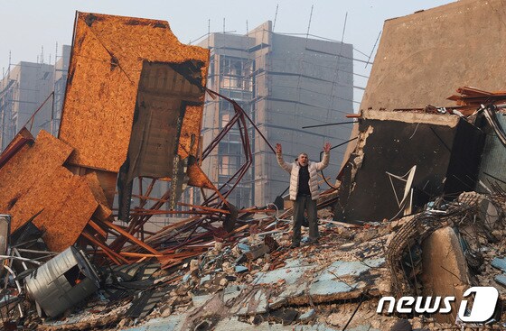 7일 튀르키예(터키) 남동부 하타이에서 강진으로 무너진 건물 폐허 속 한 남성이 두 손을 번쩍 들고 서있다. 이번 지진으로 튀르키예와 시리아에서 집계된 사망자 수는 4300명을 훌쩍 넘기고 있다. © 로이터=뉴스1 © News1 박재하 기자