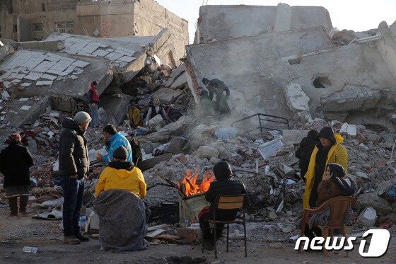 지진 발생 사흘째를 맞은 8일(현지시간) 튀르키예 카흐라만마라스에서 주민들이 무너진 건물 잔해 옆에서 구조 작업 중 잠시 쉬고 있다. © 로이터=뉴스1 © News1 최종일 기자