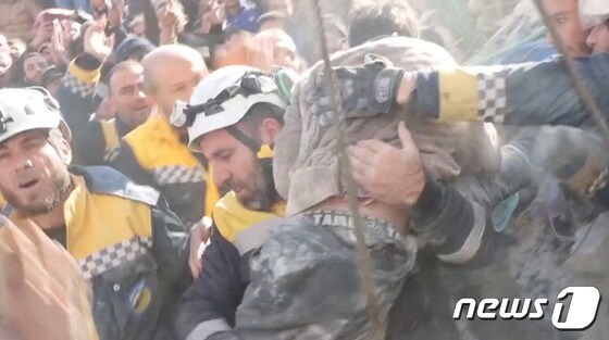 8일(현지시간) 시리아 잔다리스에서 자원봉사자들이 지진 잔해 속에서 구조한 소년을 안고 안전한 곳으로 옮기고 있다. 골든타임 72시간이 지난 후에도 기적같은 구조가 이어지고 있다. © 로이터=뉴스1 © News1 권진영 기자