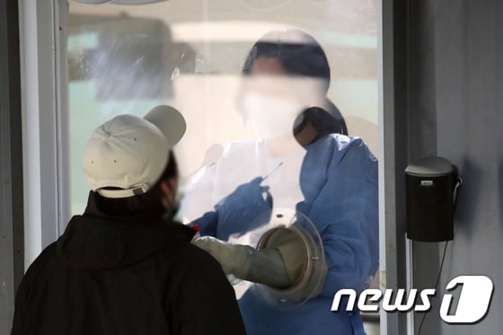 서울 용산구보건소 코로나19 선별진료소에서 한 시민이 검사를 받고 있다./뉴스1 © News1 이승배 기자