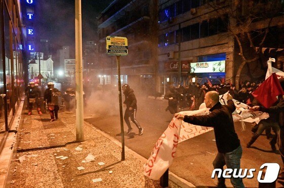 2일(현지시간) 그리스 라리사에서 발생한 최소 57명이 숨진 열차 충돌 참사에 항의하는 시위대가 아테네에 있는 헬레닉 트레인 본사 앞에서 진압 경찰과 충돌을 하고 있다. © AFP=뉴스1 © News1 우동명 기자