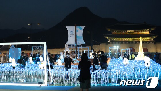 30일 오후 서울 종로구 광화문광장에서 열린 '광화에서 빛; 나이다'를 찾은 시민들이 불 밝힌 LED 장미를 살펴보고 있다. 2023.3.30/뉴스1 © News1 김진환 기자