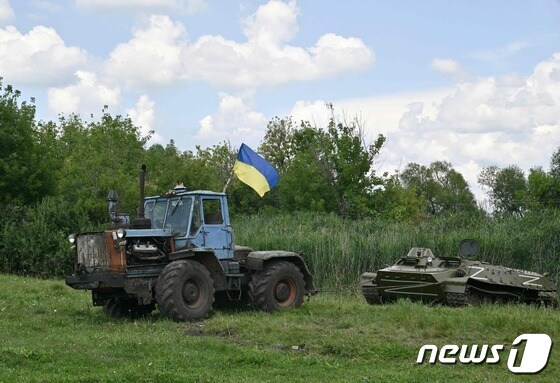 2022년 3월 말 우크라이나 북동부 하르키우 소재 말라 로간 마을 인근에서 한 농부가 국기를 단 트랙터를 타고 러시아군을 상징하는 Z가 적힌 버려진 탱크를 끌고 가고 있다. 해당 사진은 그해 7월28일 우크라이나 국영 우편서비스 우크포시타에 의해 우표로 발매됐다. © AFP=뉴스1 © News1 정윤미 기자