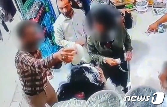 지난달 30일(현지시간) 이란 북동부 도시 마슈하드 근처의 한 마을에서 한 남성이 히잡을 착용하지 않은 모녀의 머리에 요구르트를 붓고 있다.(BBC 갈무리)