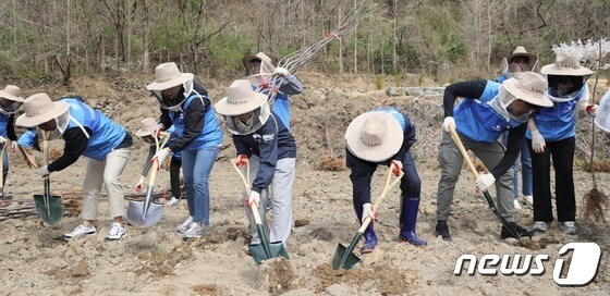 경북지역 양봉농가 지원에 나선 DGB동행봉사단 회원들이 꽃꿀과 꽃가루를 제공하는 밀원수를 심기 위해 땅을 파고 있다.(대구은행 제공)