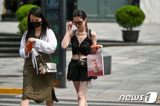 상하이가 100년래 최고 더운 5월 기온을 기록한 29일에 사람들이 거리를 걷고 있다. © AFP=뉴스1