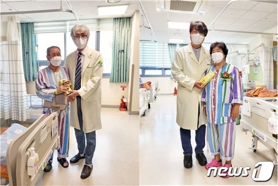  8일 대전우리병원에서 어버이날을 맞아 박철웅 대표원장(왼쪽)과 박우민 병원장(오른쪽)이 입원환자에게 카네이션과 떡을 전달하고 기념사진을 찍고 있다.(우리병원 제공)/뉴스1
