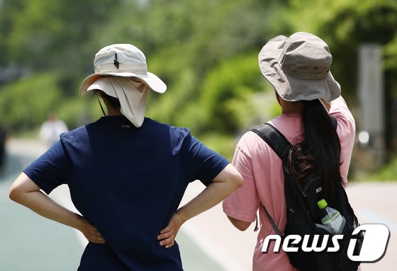 서울 서대문구 홍제천에서 시민들이 모자를 쓰고 걷고 있다. 2023.6.13/뉴스1 © News1 김민지 기자
